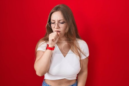 Téléchargez les photos : Jeune femme caucasienne debout sur fond rouge se sentant mal et toussant comme symptôme de rhume ou de bronchite. concept de soins de santé. - en image libre de droit