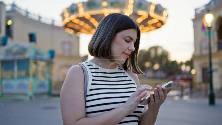 Photo for Young beautiful hispanic woman smiling happy using smartphone at Prater Vienna - Royalty Free Image