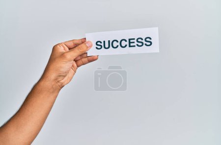 Foto de Mano de hombre caucásico sosteniendo papel con palabra de éxito sobre fondo blanco aislado - Imagen libre de derechos