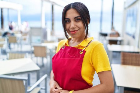 Photo for Young beautiful arab woman waitress smiling confident standing at coffee shop terrace - Royalty Free Image