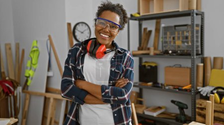 Photo for Confident woman with protective goggles stands in a carpentry workshop, embodying expertise and craftsmanship. - Royalty Free Image