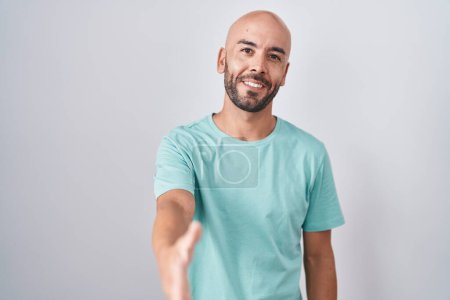 Photo for Middle age bald man standing over white background smiling friendly offering handshake as greeting and welcoming. successful business. - Royalty Free Image