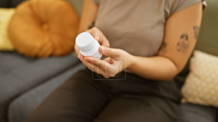 Foto de Mujer hispana examinando medicación en sala de estar - Imagen libre de derechos
