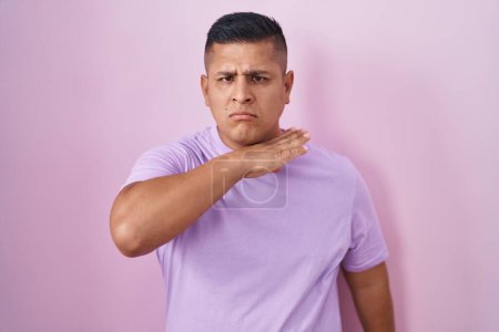 Photo for Young hispanic man standing over pink background cutting throat with hand as knife, threaten aggression with furious violence - Royalty Free Image