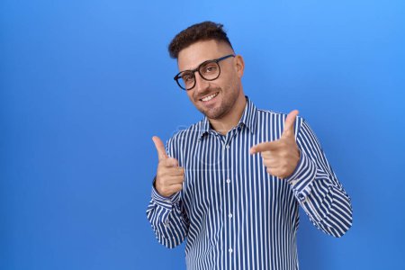 Photo for Hispanic man with beard wearing glasses pointing fingers to camera with happy and funny face. good energy and vibes. - Royalty Free Image