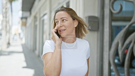 Foto de Mujer rubia joven hablando por teléfono en la calle - Imagen libre de derechos