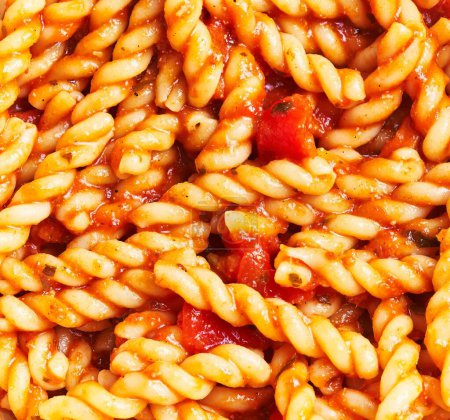 Téléchargez les photos : Image en gros plan de pâtes fusilli cuites à la sauce tomate, représentant la cuisine italienne avec une sensation rustique - en image libre de droit
