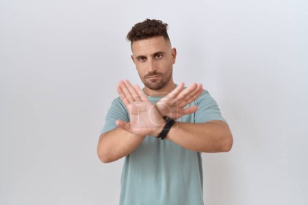 Photo for Hispanic man with beard standing over white background rejection expression crossing arms and palms doing negative sign, angry face - Royalty Free Image