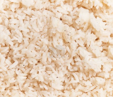 Téléchargez les photos : Texture en gros plan du riz blanc cuit sur un fond plein, adapté aux thèmes culinaires et aux contextes alimentaires. - en image libre de droit