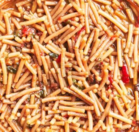 Foto de Una vista de cerca de un plato tradicional de pasta italiana e fagioli, mostrando frijoles, fideos y verduras en un caldo de tomate. - Imagen libre de derechos