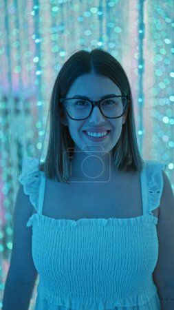 Foto de Una hermosa mujer hispana sonriente con gafas experimenta una exposición de luz futurista en un museo moderno, una exposición de arte inmersivo que genera creatividad y felicidad - Imagen libre de derechos