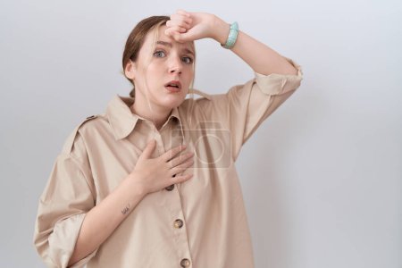 Foto de Mujer caucásica joven con camisa casual tocando la frente por enfermedad y fiebre, gripe y resfriado, virus enfermo - Imagen libre de derechos