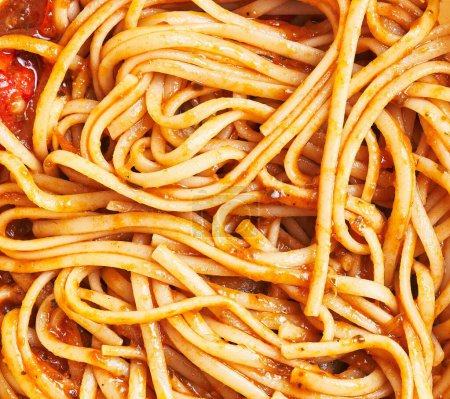 Foto de Primer plano de la pasta de espaguetis en salsa de tomate, capturando la textura y la cocina italiana. - Imagen libre de derechos
