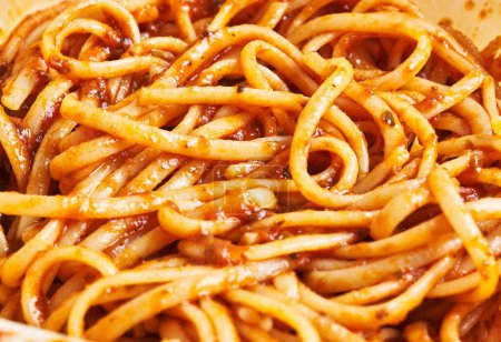 Foto de Primer plano de pasta de espaguetis recubierta de salsa marinara, evocando una experiencia culinaria italiana. - Imagen libre de derechos