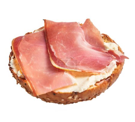 Photo for Wholegrain bagel topped with cream cheese and slices of prosciutto isolated on white - Royalty Free Image
