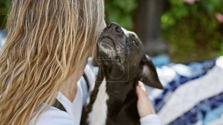 Téléchargez les photos : Une jeune femme caresse affectueusement son labrador noir dans un cadre de parc extérieur serein. - en image libre de droit