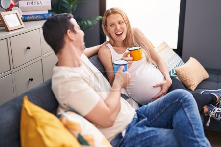 Téléchargez les photos : Homme et femme couple attendant bébé boire du café à la maison - en image libre de droit