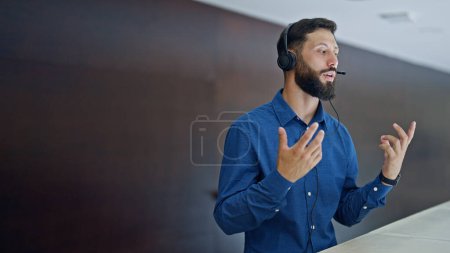 Photo for Young hispanic man business worker having free hands call at the office - Royalty Free Image