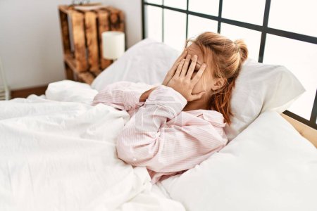 Téléchargez les photos : Young caucasian woman stressed lying on bed at bedroom - en image libre de droit