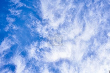 Photo for Blue sky with wispy cirrus clouds conveying a sense of tranquility and spaciousness, ideal for backgrounds. - Royalty Free Image