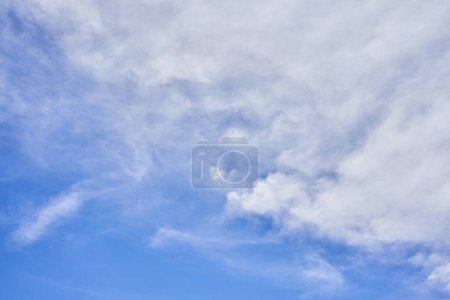 Téléchargez les photos : Un ciel serein avec des cumulus moelleux et des nuages de cirrus sanglants sur un fond bleu clair, capturant l'essence d'une journée calme. - en image libre de droit
