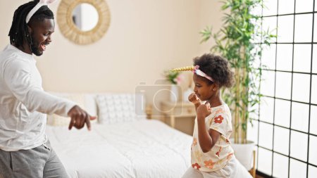 Foto de Afro-americanos padre e hija usando divertido diadema bailando en el dormitorio - Imagen libre de derechos