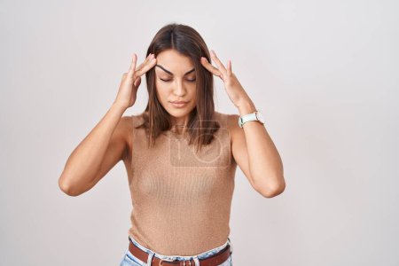 Photo for Young hispanic woman standing over white background with hand on head, headache because stress. suffering migraine. - Royalty Free Image
