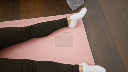 Téléchargez les photos : Belle femme blonde reposant dans une méditation matinale tranquille, allongée sur un tapis de yoga dans la chambre, éveillant des sensations de détente et de calme - en image libre de droit