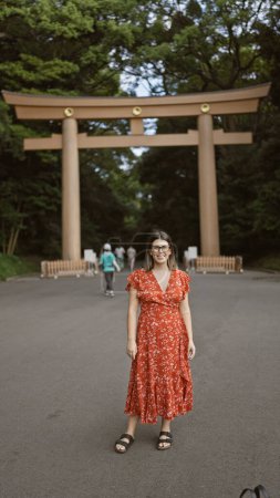 Fröhliche, schöne hispanische Frau mit Brille posiert selbstbewusst und lächelt Tokyos Meiji-Schrein an, ihre Freude strahlt eindeutig durch ihr erstaunliches Lächeln