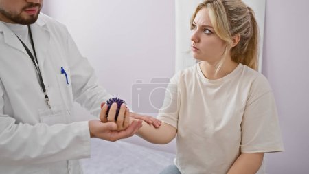 Hombre fisioterapeuta usando bola de púas en el brazo de la mujer paciente en la sala de rehabilitación blanca