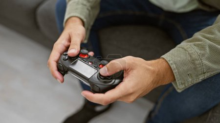 Photo for A focused young man enjoys gaming with a controller in a cozy living room setting at home. - Royalty Free Image