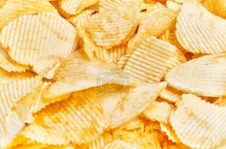 Photo for Close-up view of crispy golden potato chips, perfect for snack or food related content. - Royalty Free Image
