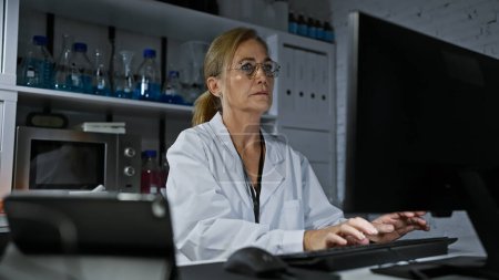 Photo for Mature woman scientist working with computer in a laboratory environment - Royalty Free Image