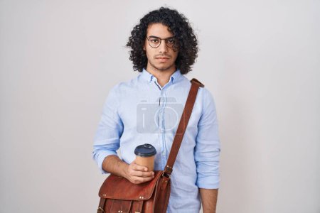 Photo for Hispanic man with curly hair drinking a cup of take away coffee skeptic and nervous, frowning upset because of problem. negative person. - Royalty Free Image
