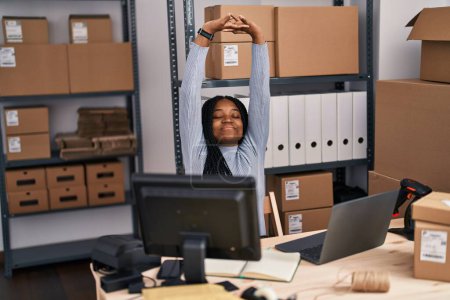 Téléchargez les photos : Africaine américaine femme commerce électronique travailleur d'affaires en utilisant un ordinateur portable étirant les bras à la rue - en image libre de droit