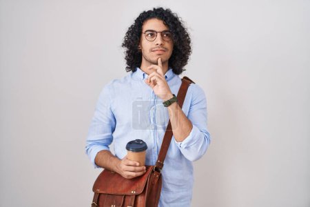 Photo for Hispanic man with curly hair drinking a cup of take away coffee thinking concentrated about doubt with finger on chin and looking up wondering - Royalty Free Image