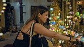 A young woman touches colorful lamps at a traditional souk in dubai, admiring the vibrant arabian craft. puzzle #699239824