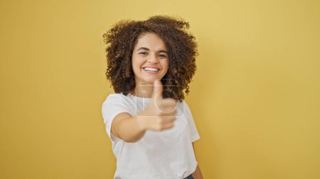 Photo for Young beautiful hispanic woman smiling with thumb up over isolated yellow background - Royalty Free Image
