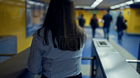 Photo for Young beautiful hispanic woman checking ticket on subway toll gate in subway station of Madrid - Royalty Free Image