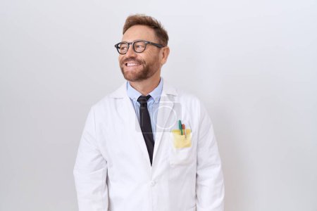 Photo for Middle age doctor man with beard wearing white coat smiling looking to the side and staring away thinking. - Royalty Free Image