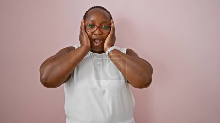 Photo for Wow! happy african american woman with braids, in casual wear, standing in sheer amazement, cheerfully expressing surprise, over an isolated pink background wall. - Royalty Free Image