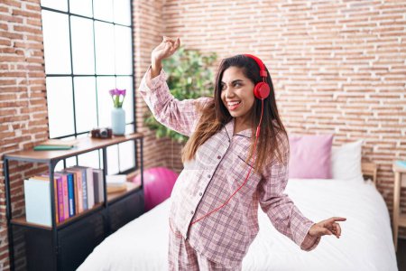 Téléchargez les photos : Jeune belle femme arabe écoutant de la musique et dansant dans la chambre - en image libre de droit