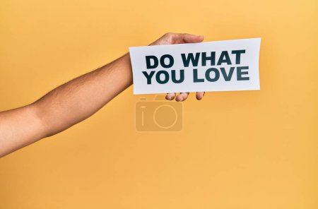 Photo for Hand of caucasian man holding paper with do what you love message over isolated white background - Royalty Free Image