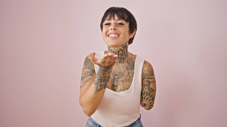 Téléchargez les photos : Femme hispanique avec bras amputé souriant baiser soufflant confiant sur fond rose isolé - en image libre de droit