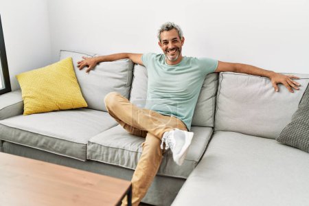 Photo for Middle age grey-haired man smiling confident sitting on sofa at home - Royalty Free Image