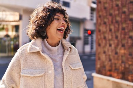 Foto de Young beautiful hispanic woman smiling confident looking to the side at street - Imagen libre de derechos
