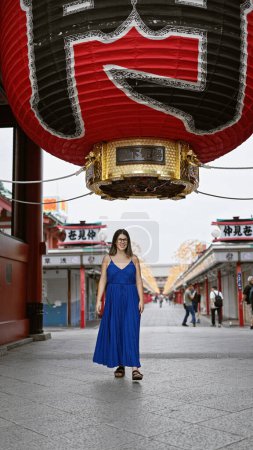 Photo for Beautiful hispanic woman donning glasses, flashing a cheerful smile at the senso-ji temple, immersed in japanese tradition, joyful latin adult exploring the rich culture of tokyo - Royalty Free Image