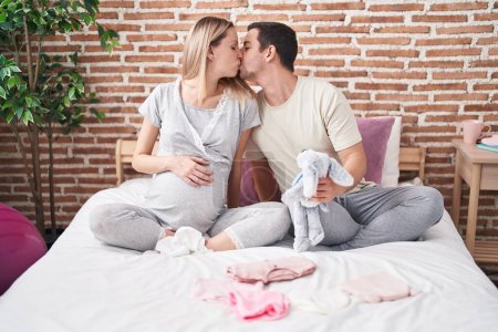 Téléchargez les photos : Homme et femme couple tenant poupée pour le bébé baisers à chambre - en image libre de droit