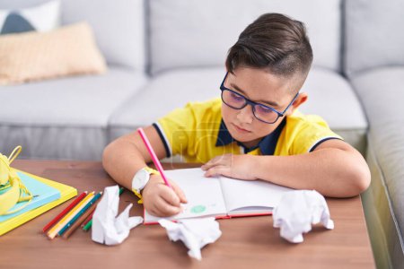 Photo for Adorable hispanic boy drawing on book sitting on floor at home - Royalty Free Image