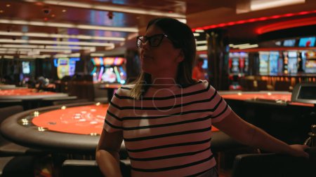 Foto de Una joven hispana adulta en un casino, encarna el ocio y el estilo en medio del encanto del juego. - Imagen libre de derechos